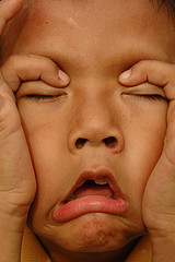 annoyed8yo close up of child with hands on face in frustration