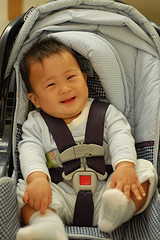 asian child in car seat smiling
