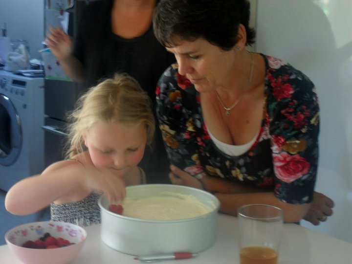 Mom watching daughter place fruit on dessert